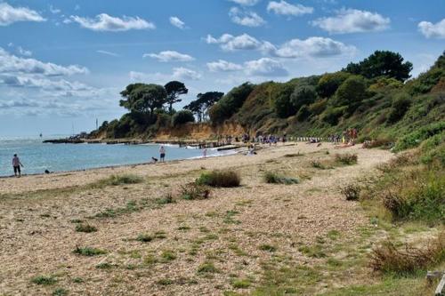 a group of people walking on a beach at Elmside, The Luxury New Forest Retreat in Southampton