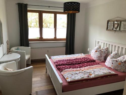 1 dormitorio con cama y ventana en Ferienwohnung Landhaus zum Sonnenschein, en Marquartstein