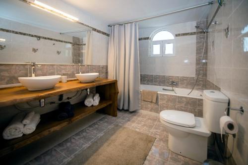 a bathroom with two sinks and a toilet and a tub at Villa Giota Luxury Living in Theologos