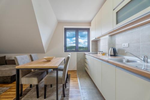 a kitchen with a wooden table and a sink at Monix Palace Zlatibor in Zlatibor