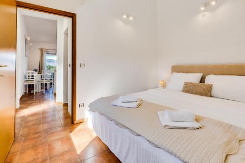 a bedroom with a large white bed with towels on it at Apartments Habek in Vrboska