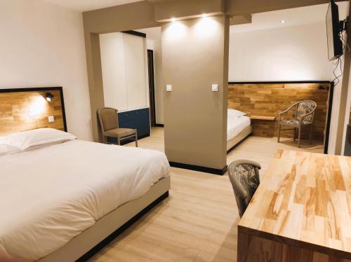 ヴァランシエンヌにあるModern'Hotelのベッド、テーブル、椅子が備わるホテルルームです。