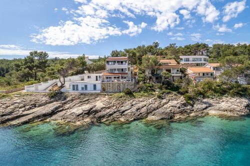 an aerial view of a house on a rocky island in the water at Apartments Habek in Vrboska