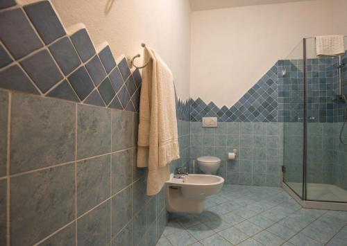 e bagno piastrellato blu con servizi igienici e doccia. di Turismo Rurale CUDACCIOLU a Arzachena