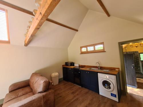 cocina con lavadora y secadora en una habitación en Gatwick hideout en Charlwood