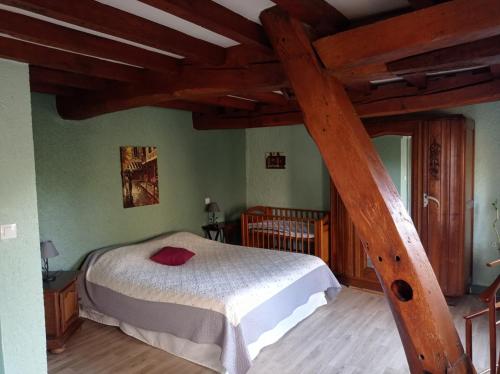a bedroom with a bed in a room with wooden beams at GITE DU MOULIN in Renty