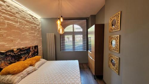 a bedroom with a bed and a brick wall at Apartament Złote Żdżadło Nikiszowiec in Katowice