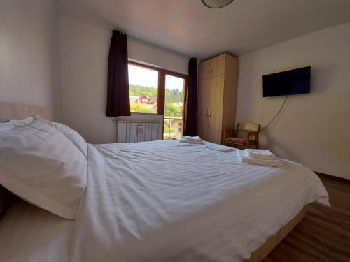 ブシュテニにあるC Houseのベッドルーム(大きな白いベッド1台、窓付)
