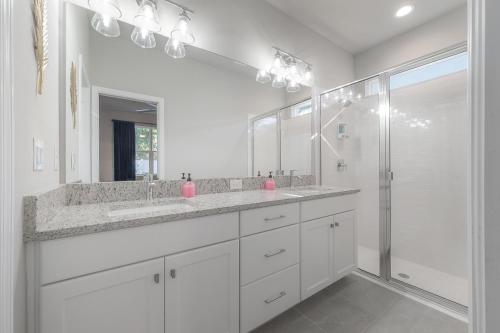 タンパにあるPet Friendly Home in Ybor City!の洗面台2つとシャワー付きの白いバスルーム