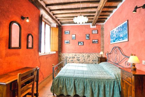 1 dormitorio con paredes de color naranja y 1 cama con colcha azul en Verzure, en Montingegnoli