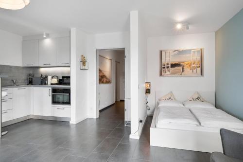 a living room with a white couch and a kitchen at Stadtkernnahes Wohnen in Düren in Düren - Eifel