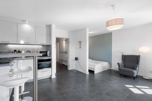 a kitchen with white cabinets and a bed in a room at Stadtkernnahes Wohnen in Düren in Düren - Eifel