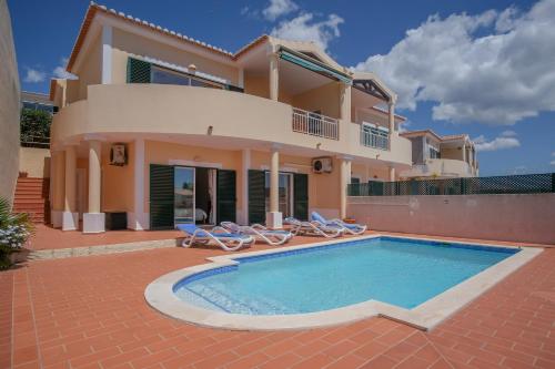 a villa with a swimming pool in front of a house at Villa Acacias 18, Brisa do Mar in Luz