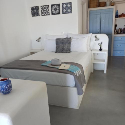 a bedroom with a white bed and a blue cabinet at Kykladonisia Amorgos in Amorgos
