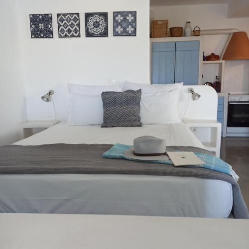 a white bed with a hat and a book on it at Kykladonisia Amorgos in Amorgos