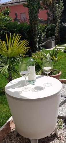two wine glasses on a table with a bottle of wine at Residenza La Dimora ImPerfetta in Salionze
