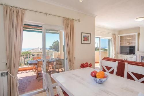 a kitchen and dining room with a table with a bowl of fruit at Villa Acacias 18, Brisa do Mar in Luz