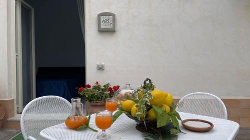 a table with a bowl of fruit and juice on it at Villaggio Villa Lubrense in Massa Lubrense
