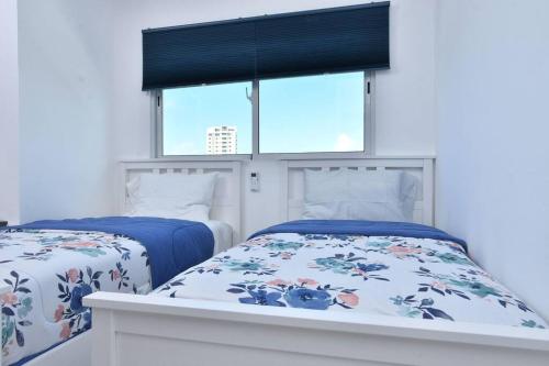 a bedroom with two beds and a window at Apto Juan Dolio Tepuy 601 F in Juan Pedro