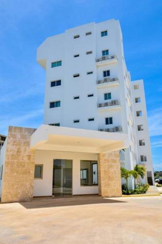 a tall white building in front of a building at Apto Juan Dolio Tepuy 601 F in Juan Pedro
