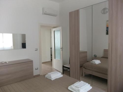 a white room with a mirror and a bed at Casa Vergara Piazza Mazzini in Lecce
