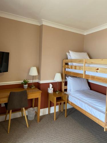a bedroom with a bunk bed and a desk at The Wellington Hotel in Ventnor