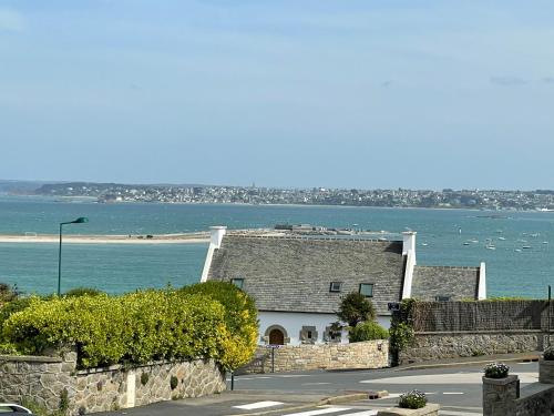 une maison sur le côté d'une route à côté de l'eau dans l'établissement La Bidouric, Jacuzzi, à Saint-Pol-de-Léon