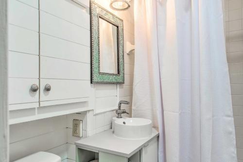 een witte badkamer met een wastafel en een spiegel bij St Simons Cottage with Grill about 2 Mi to Beach! 