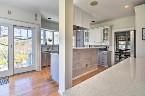 a kitchen with white cabinets and a large island at Charming Retreat with Fire Pit and Spacious Yard! 