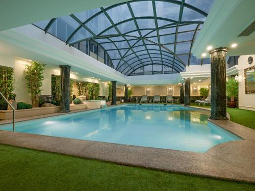 - une grande piscine dans un bâtiment doté d'un plafond en verre dans l'établissement Richmonde Hotel Ortigas, à Manille