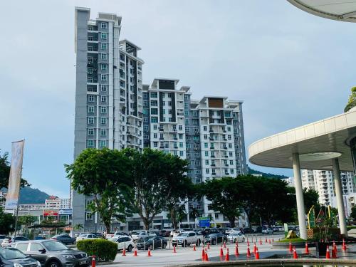 a parking lot with cars parked in front of tall buildings at Spice Tunas 3B2B House in Bayan Lepas