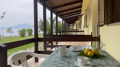 een tafel met twee kopjes en fruit op een balkon bij Villaggio Villa Lubrense in Massa Lubrense