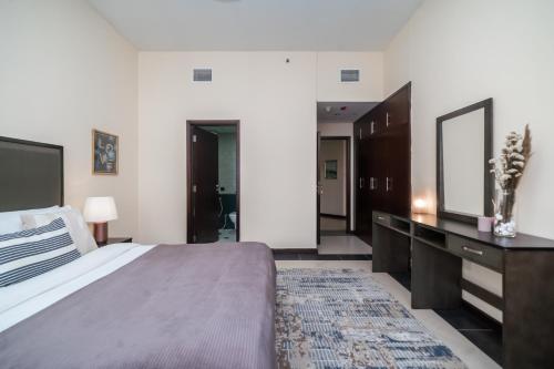 una camera da letto con un letto, un comò e uno specchio di HiGuests - Deiras Lucky Find, 5-min to the Airport a Dubai