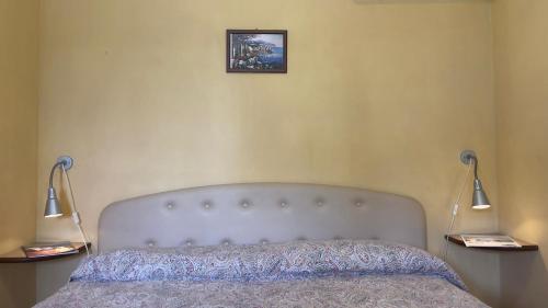 a bed in a bedroom with two lamps and a picture on the wall at Villaggio Villa Lubrense in Massa Lubrense