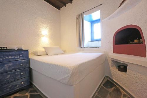 um quarto com uma cama com uma cómoda e uma janela em Le petit château em Ano Syros