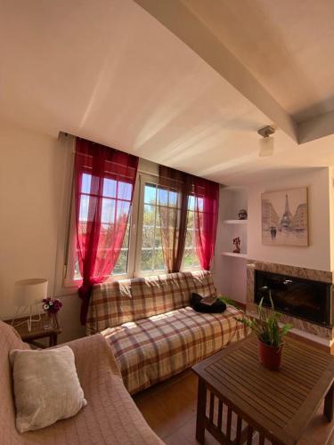 a living room with a couch and two windows at Casa Hortiñas in Chancelas