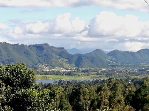 a view of a valley with a lake and mountains at AIKA Reserva Glamping Tabio in Tabio