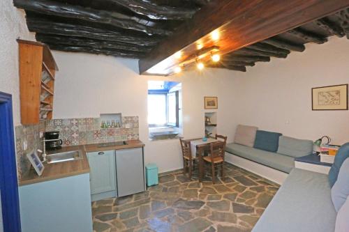 uma cozinha e sala de estar com um sofá e uma mesa em Le petit château em Ano Syros
