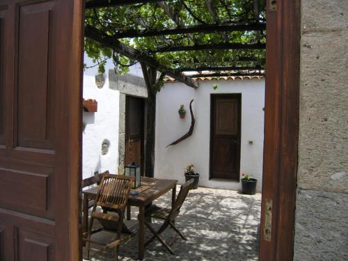 una puerta abierta a un patio con mesa y sillas en La Casita de Andres 1 en Agüimes
