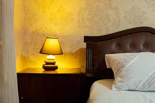 a lamp on a night stand next to a bed at Nino's Guest House in Tbilisi City