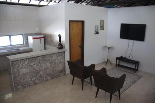 a living room with chairs and a flat screen tv at Hotel Fazenda Lago São Francisco in São João