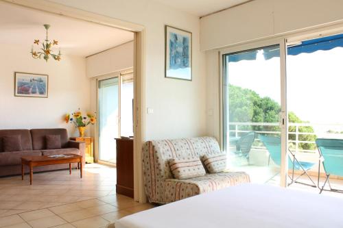 un salon avec un canapé et une chaise dans l'établissement Grand appartement pour 6 pers dans une résidence de standing avec piscine à 2 pas de la plage et du centre ville, à Cavalaire-sur-Mer