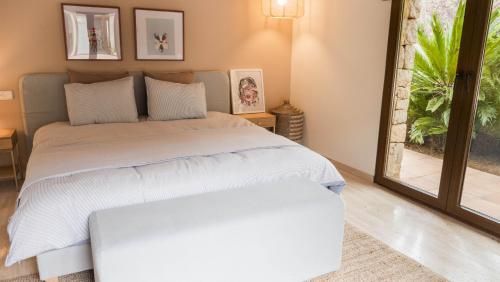 a bedroom with two beds and a large window at Villa Casa Del Talaiot Sencelles in Sencelles