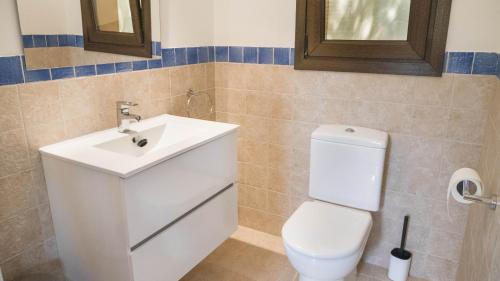 a bathroom with a white toilet and a sink at Villa Casa Del Talaiot Sencelles in Sencelles