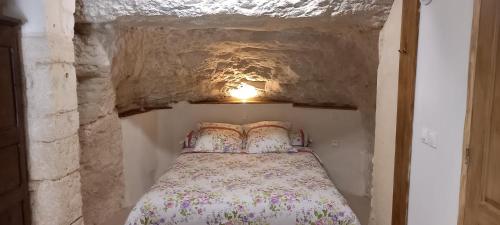 a small bedroom with a bed in a cave at gite-civray-de-touraine TROGLO de Denise in Civray-de-Touraine