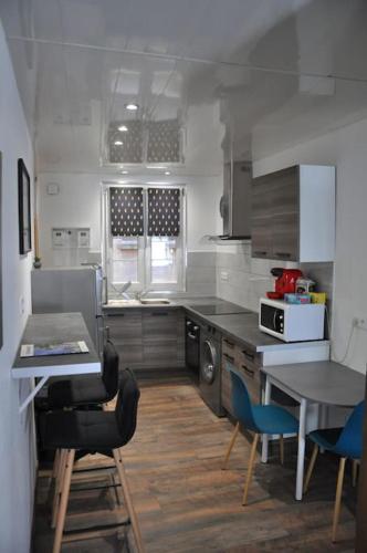 une cuisine avec une table et des chaises bleues. dans l'établissement Le Studio du Tanneur Selestadien, à Sélestat