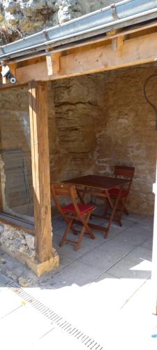 une table et deux chaises assises sous un bâtiment dans l'établissement gite-civray-de-touraine TROGLO de Denise, à Civray-de-Touraine