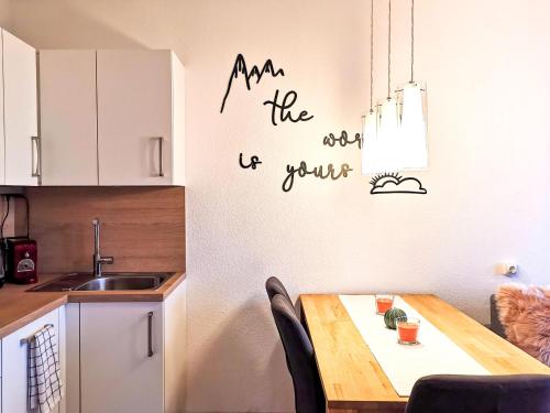 a kitchen with a table and a sign on the wall at Jonas Deluxe Apartment Panoramablick in Bad Goisern