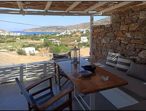 a wooden table and chairs on a patio with a view at Kykladonisia Amorgos in Amorgos