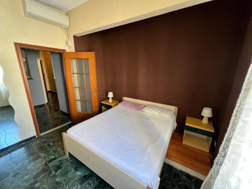 een slaapkamer met een wit bed en een bruine muur bij Bilocale Pf in Loano
